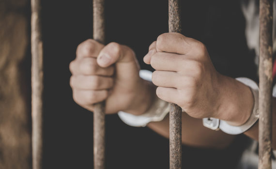 Man holding prison bars