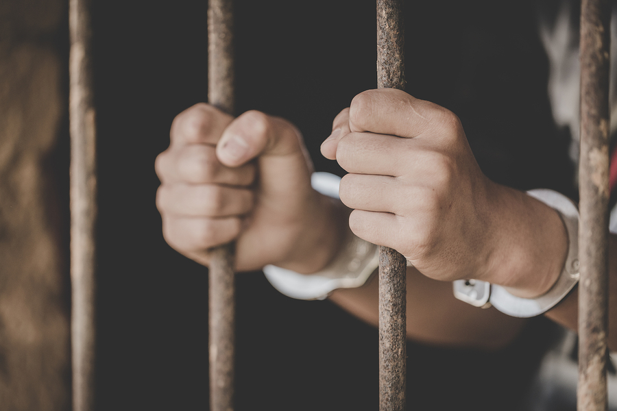 Man holding prison bars