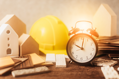 Hard hat with construction materials and an alarm clock